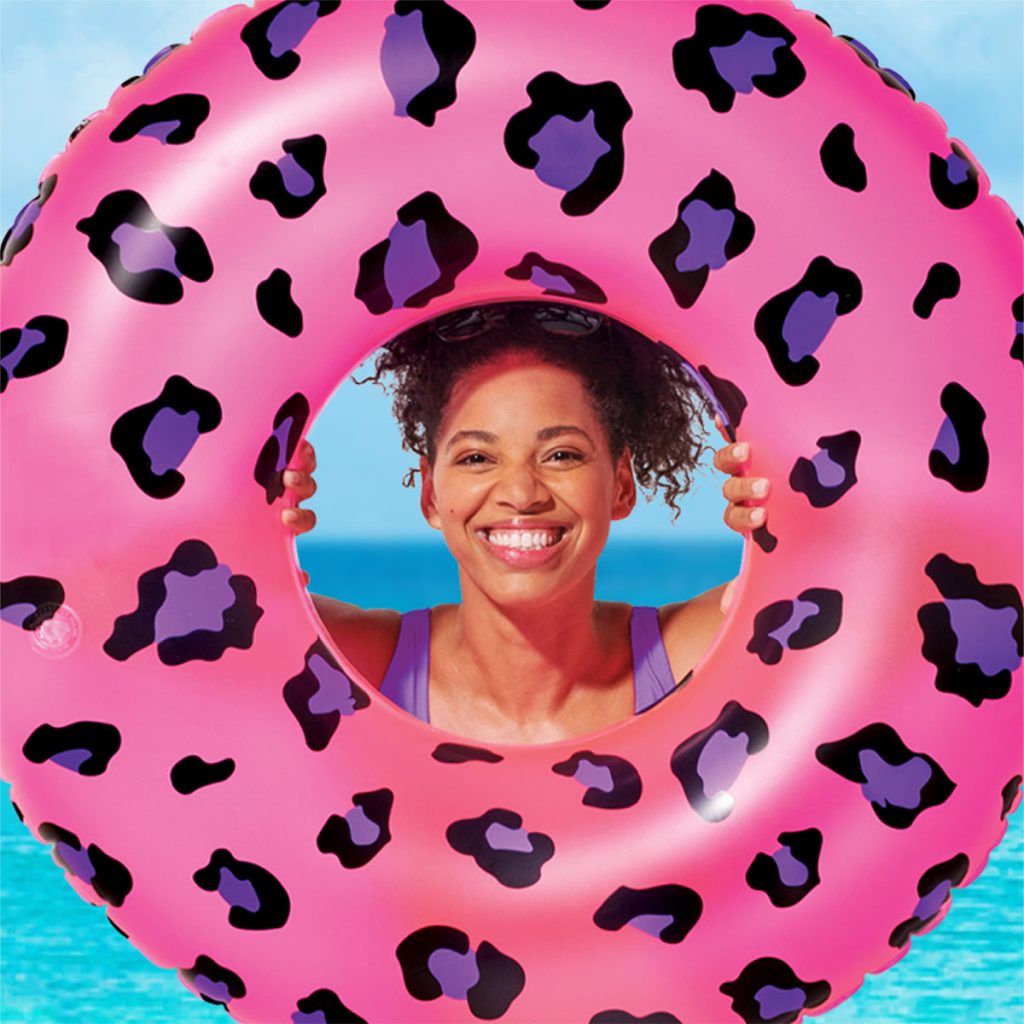 Lifestyle product photography: photograph of female model with inflatable pool float pink leopard skin doughnut